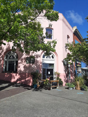 Heritage storefront painted soft pink with white window trim