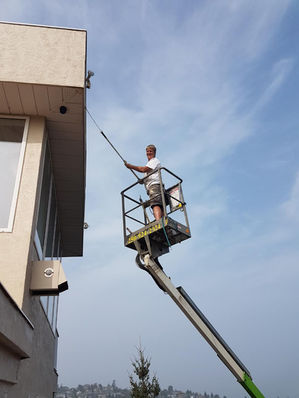 Painter working from a boom lift on a multi-storey exterior
